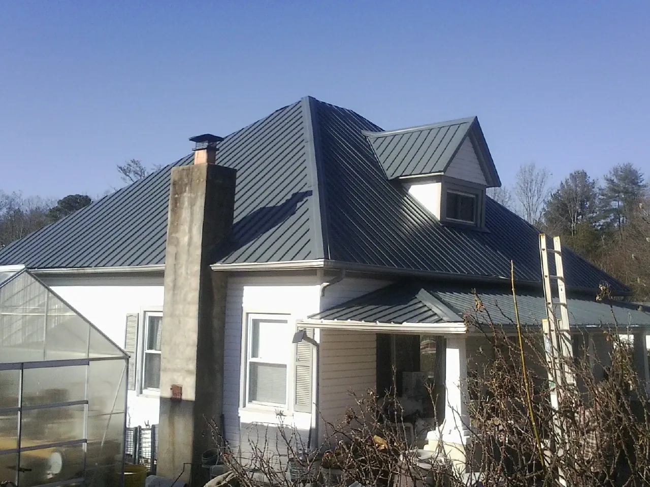 Dark blue standing seam metal roof on a white farmhouse with dormer — Slate & Tile Roof Repair by Roofing Brothers in Somerdale