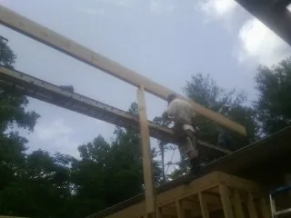Carpenter setting a ridge beam over a new addition frame — Ice Dam Removal by Roofing Brothers in Somerdale