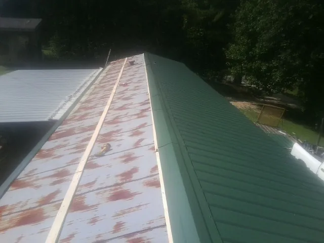 Old rusted panels beside newly installed green metal roofing — Wind Damage Roof Repair by Roofing Brothers in Somerdale