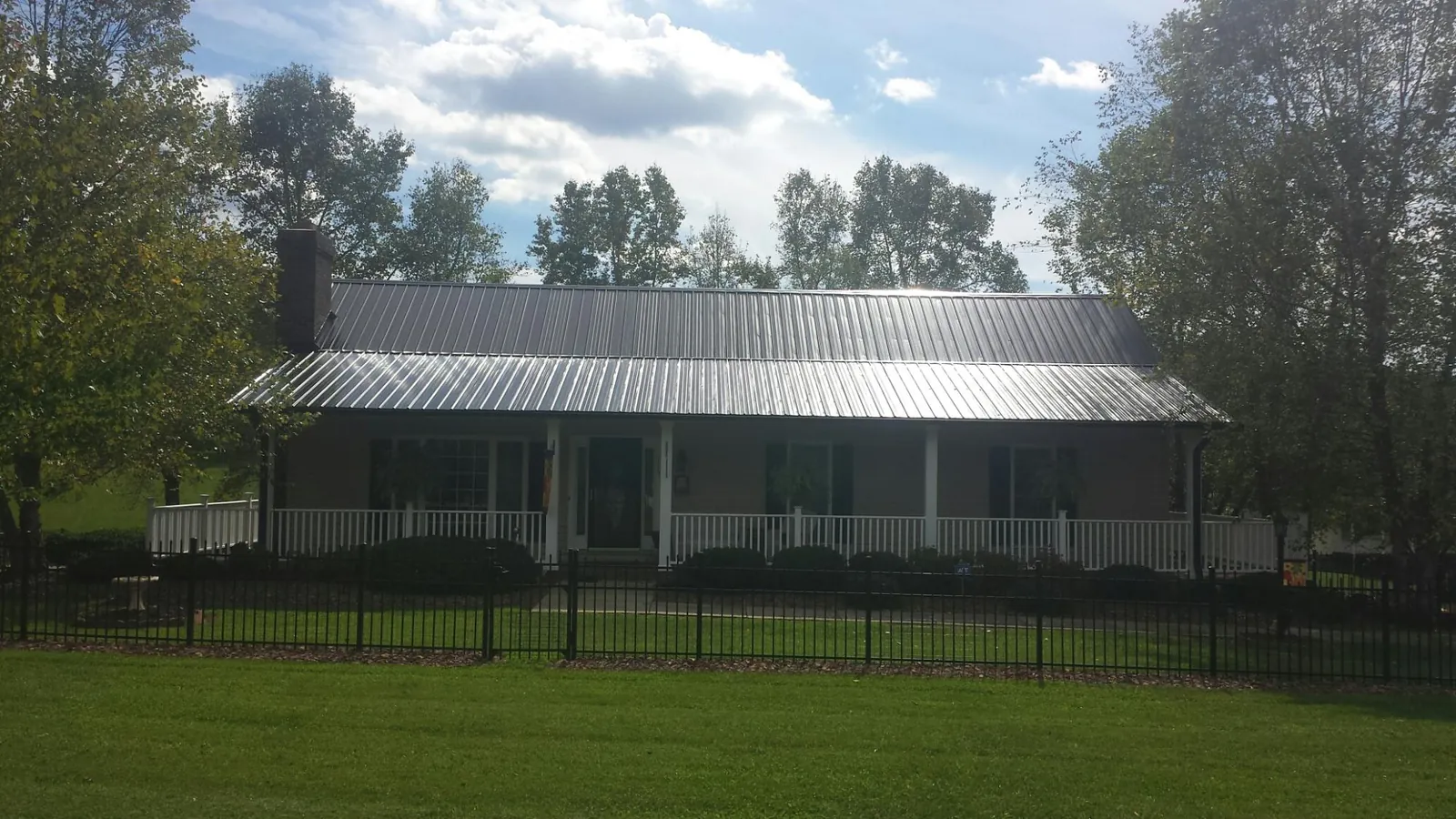 Gray metal roof on a brick ranch with a full width front porch — Gutter Guard Installation work by our crew in Somerdale